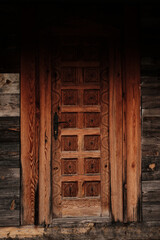 Fototapeta premium Close-up of a traditional carved wooden door in village Drvengrad, Serbia, highlighting intricate patterns and textures