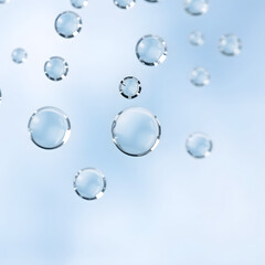 "Close-Up of Clear Water Droplets Floating in Air on Blue Background, Macro Shot of Transparent Bubbles Representing Purity, Freshness, and Clean Natural Elements"