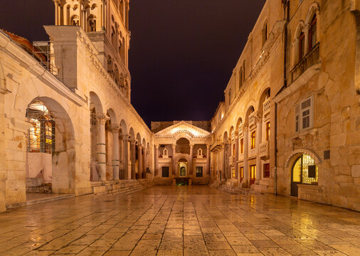 View of the Peristyle courtyard of Diocletian Palace in Split Croatia illuminated at night with historic Roman architecture.