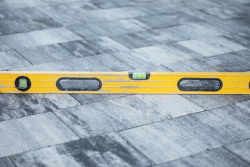 Fototapeta premium Poziomica na kostce brukowej Brukarstwo Brukarz / Spirit level on paving stones