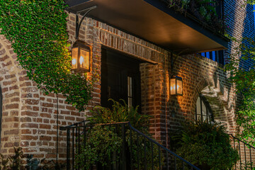 Historic brick house facade with lanterns at night