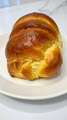 French Brioche Bread with Golden Crust and Soft Buttery Texture Served on White Plate for Premium Bakery Object and Gourmet Food Concept