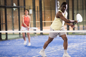 Obraz premium African american man playing paddle tennis indoors