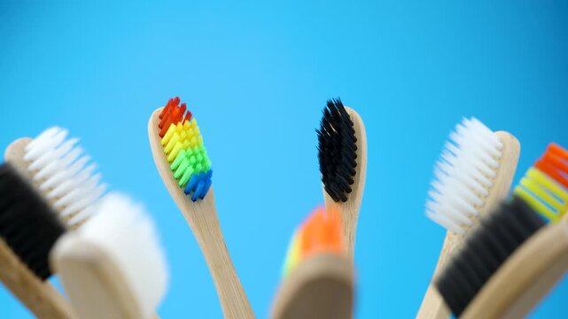 Eco-friendly bamboo toothbrushes with black, white, and rainbow bristles. Concept of zero waste, dental care, color contrast, and personal choice in sustainable hygiene products