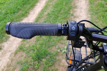 Left rubberized grip with palm rest and buttons of the on-board computer on an electric bicycle