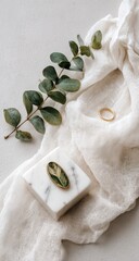 Elegant minimalist still life with eucalyptus ring and marble block.