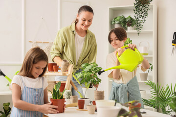 Mother with her children taking care of plants in workshop