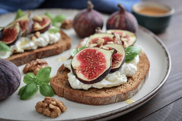 Sandwiches with figs, cream cheese, basil and honey on plate