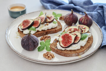 Sandwiches with figs, cream cheese, basil and honey on plate