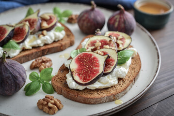 Sandwiches with figs, cream cheese, basil and honey on plate