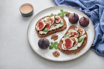 Sandwiches with figs, cream cheese, basil and honey on plate