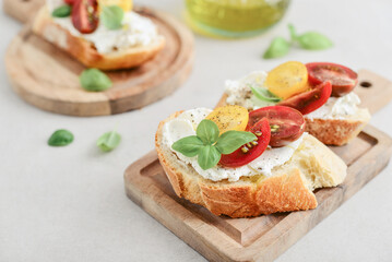 Bruschetta sandwiches with tomatoes, cream cheese, olive oil and basil on a plate