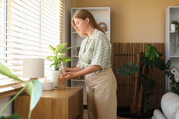Female interior designer putting statuette on chest of drawers in living room