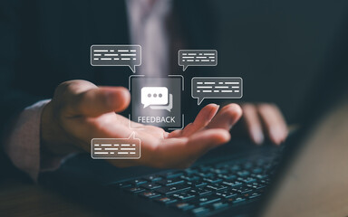 Hands holding feedback interface with floating chat bubbles and message boxes above laptop keyboard. Customer feedback collection and communication management system concept visualization.