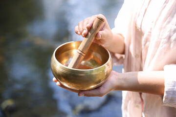 Woman with singing bowl in nature, closeup
