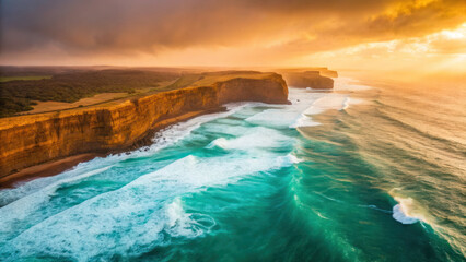 Breathtaking aerial view of dramatic coastline cliffs with turquoise waves crashing below, illuminated by vibrant golden sunset