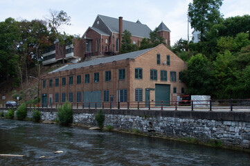 Historic Red Brick Industrial Mill Building with Green Shutters and Smokestack Architecture