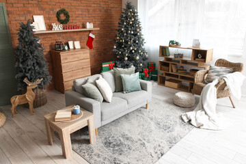 Interior of living room with Christmas trees, sofa and bookshelf