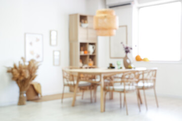 Blurred view of light dining room with table, shelf unit and pumpkins