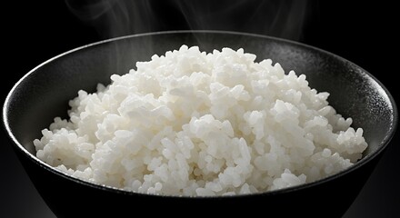Steaming white rice in a dark bowl with wisps of steam rising cooked rice steamed rice