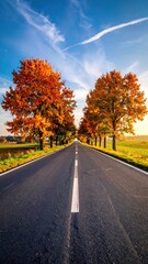 Naklejka premium Majestic Autumn Road Surrounded by Vibrant Orange and Yellow Trees
