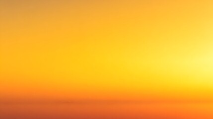 Fototapeta premium A breathtaking golden hour sunset over the ocean, with a vibrant orange and yellow sky and a calm, reflective sea.