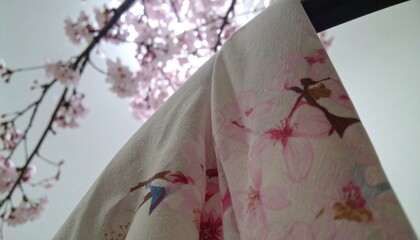 Soft, delicate fabric draped against a backdrop of cherry blossoms