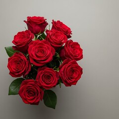 A vibrant bouquet of deep red roses sits elegantly against a neutral backdrop, showcasing their rich color and delicate petals.