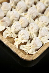 Fresh Homemade Ravioli Pasta on Wooden Board - Traditional Italian Dumplings with Meat Filling