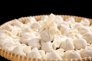 Fresh Homemade Ravioli Pasta in Wicker Basket on Black Background
