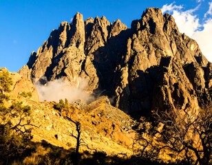 Dramatic mountain peaks, rugged slopes, and low clouds