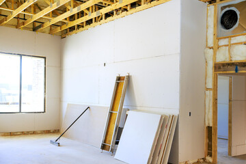 Drywall is being installed construction area features bare walls for home renovation work in progress.