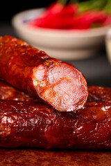 Homemade Smoked Sichuan Sausage Slices - Traditional Spicy Chinese Cured Meat on Wooden Cutting Board