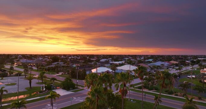 Punta Gorda, Florida waterfront at sunset with expensive mansions, palm trees and golden light over premium suburban homes.