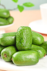 Fresh Green Mini Kiwi Fruits with Water Droplets on White Plate - Healthy Organic Food Photography