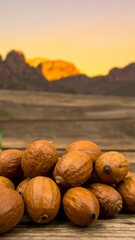 Pile of nuts on rustic wood, sunset mountains