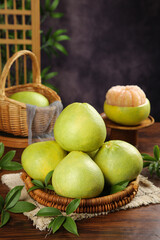 Fresh Fujian Pomelo Citrus Fruits in Wicker Baskets on Wooden Table