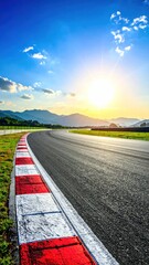 Fototapeta premium A scenic, curving racetrack stretches toward a bright sun setting behind distant mountains under a blue sky with wispy white clouds