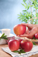 Fresh Red Apples in Hand with Coffee Cup on Wooden Table - Healthy Eating Lifestyle