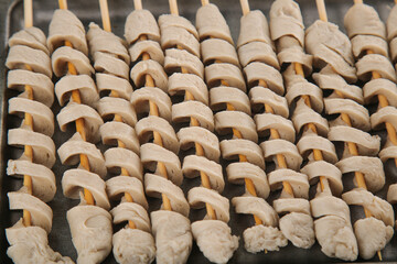 Traditional Shaanxi Gluten Skewers on Wooden Sticks Ready for Grilling - Chinese Street Food Specialty Closeup