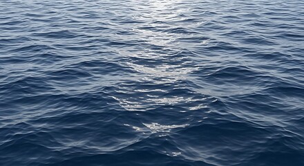 Calm blue ocean waves reflecting sunlight, a serene natural water surface with gentle ripples and sunlit patches