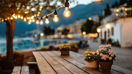 Outdoor dining table with flowers and string lights at dusk.