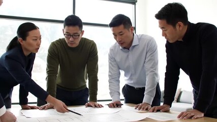 Asian business team collaborates on architectural plan for new construction project - Powered by Adobe