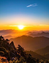 A sunburst illuminating hazy mountain ranges during sunset, with lush foliage and rocky cliffs in the foreground against a blue sky