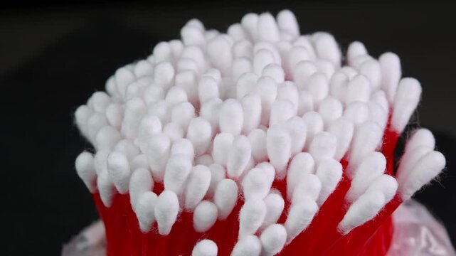 Cotton swabs rotating, cotton buds close up shot on black background. Personal hygiene and cosmetic items. Ear cleaning q-tips