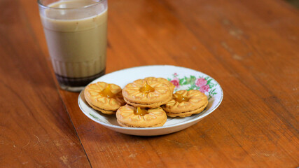 Breakfast and snack menu. Butter biscuits with pineapple jam and a glass of chocolate milk. Close-up of butter cookies and a glass of chocolate, sweet cakes. Perfect for recipes, articles, catalogs.