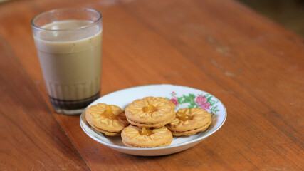 Breakfast and snack menu. Butter biscuits with pineapple jam and a glass of chocolate milk. Close-up of butter cookies and a glass of chocolate, sweet cakes. Perfect for recipes, articles, catalogs.