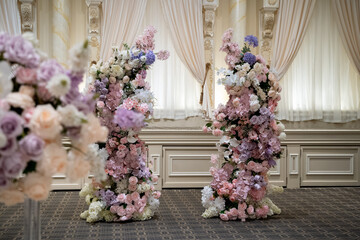 Floral wedding arch decoration with pink and white roses in elegant hall.
