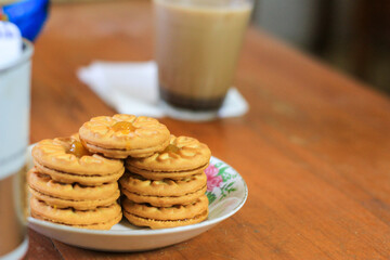 Breakfast and snack menu. Butter biscuits with pineapple jam and a glass of chocolate milk. Close-up of butter cookies and a glass of chocolate, sweet cakes. Perfect for recipes, articles, catalogs.