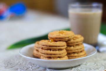 Breakfast and snack menu. Butter biscuits with pineapple jam and a glass of chocolate milk. Close-up of butter cookies and a glass of chocolate, sweet cakes. Perfect for recipes, articles, catalogs.
